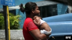 Una mujer carga a su pequeño hijo en La Habana (Cuba)14 de agosto de 2014.