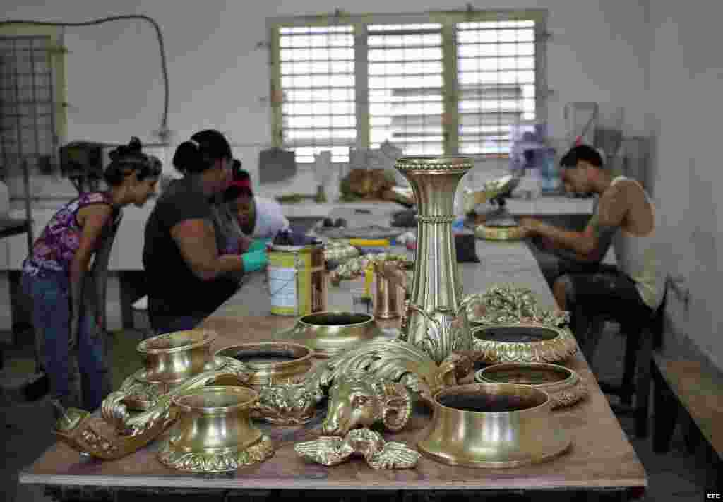 Un grupo de jóvenes trabaja en la restauración de las lámparas del Salón de los Pasos Perdidos del Capitolio Nacional de Cuba este jueves, 16 de mayo de 2013, en La Habana (Cuba). Un andamio de enormes proporciones cubre desde hace semanas la imponente cú