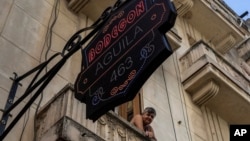 Una residente mira desde su balcón una tienda de comestibles privada en La Habana, Cuba, el sábado 11 de noviembre de 2023. (Foto AP/Ramón Espinosa)