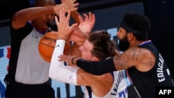 Marcus Morris Sr., (R) de LA Clippers, Luka Doncic (C) del Dallas Mavericks durante NBA Playoffs 2020 en Lago Buenavista, Florida.