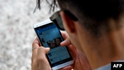 Un joven se conecta a Internet desde su teléfono en La Habana. (YAMIL LAGE / AFP)