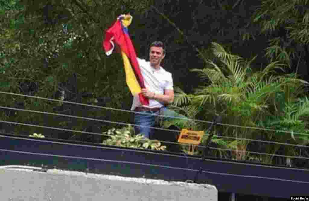 Luciendo una camiseta blanca, un sonriente Leopoldo López levantó las manos en señal de victoria, desde el jardín de su casa, en medio de la ovación de decenas de simpatizantes que lo esperaban afuera.