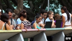 Varios jóvenes navegan por internet usando una red WiFi en La Habana.