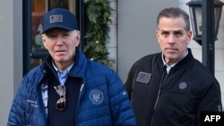 Una fotografía del 29 de noviembre de 2024 muestra al presidente estadounidense Joe Biden y a su hijo Hunter Biden saliendo de una librería mientras compran en Nantucket, Massachusetts.