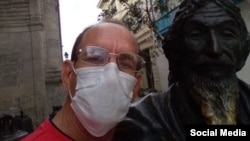 El profesor cubano Pedro Albert Sánchez, junto a la estatua del Caballero de París, en La Habana Vieja. (Foto: Facebook)