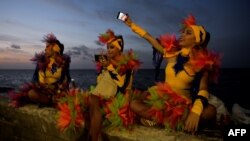 Bailarinas cubanos se fotografían con sus celulares. AFP/ Yamil Lage