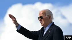 El presidente de Estados Unidos, Joe Biden, saluda mientras aborda el Air Force One antes de despegar del aeropuerto regional del condado de Dane en Madison, Wisconsin, el 5 de julio de 2024, mientras viaja a Wisconsin para eventos de campaña. SAUL LOEB / AFP