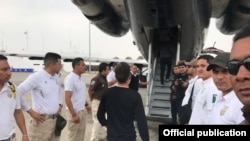 Un migrante cubano camino al avión que lo llevó de regreso a la isla.