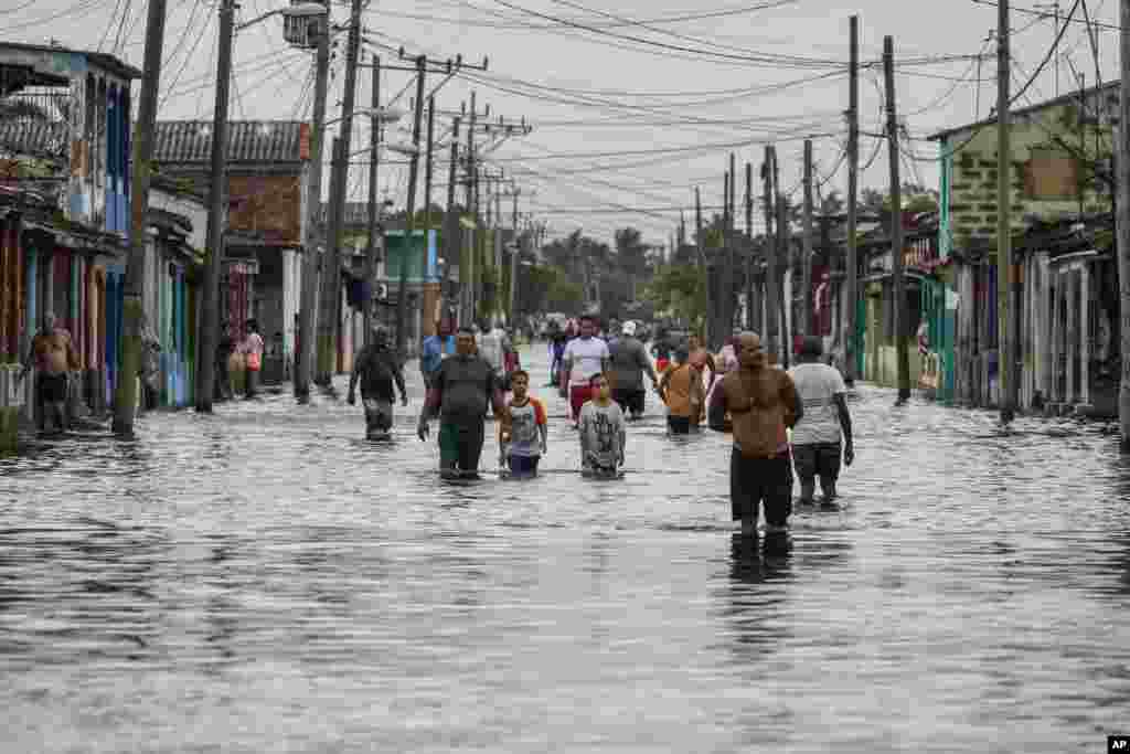 Residentes de Batabanó caminan por las calles inundadas por las lluvias de la tormenta Helene.