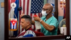 Un barbero usa máscara de protección contra el coronavirus en La Habana. (AP/Ramon Espinosa)