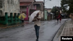 La gente camina por la calle mientras la tormenta tropical Helene pasa cerca de la costa cubana, Pinar del Río, Cuba, el 25 de septiembre de 2024. REUTERS/Stringer