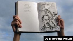 Un cubano alza un libro con la imagen y versos del apóstol José Martí. (Foto: Roberto Koltun/OCB/Archivo)