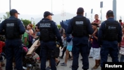 Policía federal custodia caravana de migrantes en Huixtla.