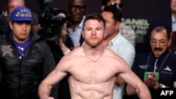 El boxeador Saúl "Canelo" Álvarez posa en la balanza durante su pesaje con Julio César Chávez, Jr., en el MGM Grand Arena en Las Vegas, Nevada.