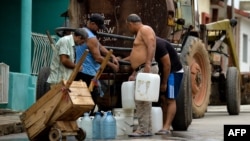 Vecinos recogen agua de una pipa la mañana del martes en un barrio de San Antonio de los Baños, en la provincia de Artemisa (Yamil Lage/AFP).