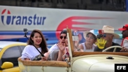 Turistas se toman una selfie durante un paseo en un auto clásico en La Habana.