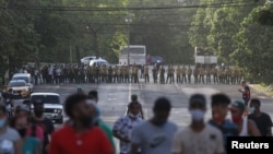 Manifestantes se alejan de los oficiales del MININT que bloquean una calle durante la protesta del 11 de julio en La Habana. (REUTERS/Alexandre Meneghini).