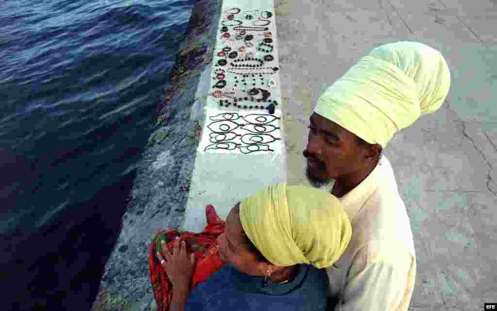 Una pareja de rastafaris vende artesanías en el Malecón de La Habana (Cuba).