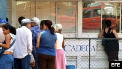 Varias personas hacen cola frente a una Casa de Cambio (CADECA).