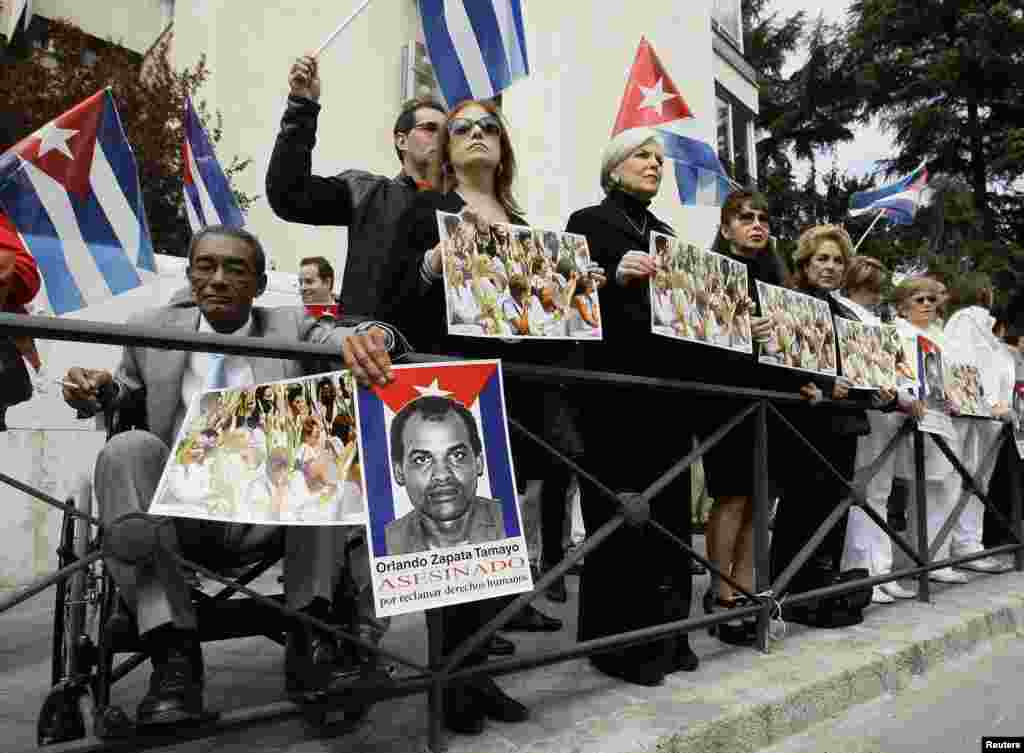 Activistas muestran carteles de las Damas de Blanco y Orlando Zapata Tamayo, frente a la Embajada de Cuba en Madrid, España en marzo de 2010. REUTERS/Andrea Comas