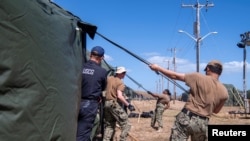 Marineros de la Marina de EEUU y miembros de la Guardia Costera erigen tiendas de campaña expedicionarias en la Estación Naval de la Bahía de Guantánamo