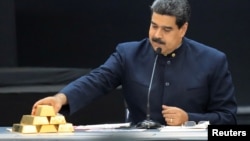 Nicolás Maduro toca una barra de oro mientras se dirige a los ministros responsables del sector económico en el Palacio de Miraflores. 