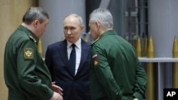 El presidente ruso, Vladimir Putin, en el centro, conversa con el jefe del Estado Mayor ruso, el general Valery Gerasimov (izq) y el recién destituido ministro de Defensa ruso, Sergei Shoigu. (Mikhail Klimentyev, Sputnik, Kremlin Pool Photo via AP, Archivo)