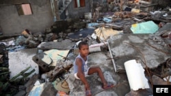 Un niño sentado en los escombros tras el paso del huracán Matthew en Baracoa. EFE/Alejandro Ernesto