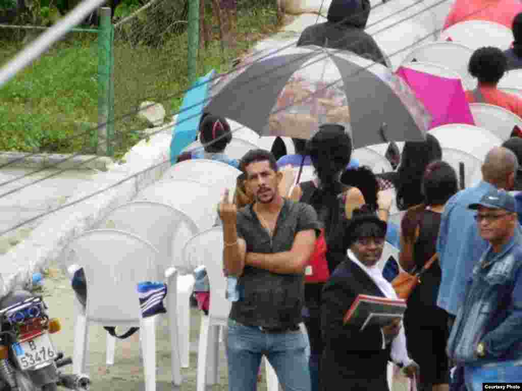 Un civil hace un gesto obsceno a las Damas de Blanco en su sede de Lawton, en La Habana, el 21 de enero de 2016. Foto cortesía Ángel Moya.