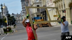 Trabajadores cargan unos marcos de ventana.