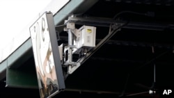 Un dispositivo de radar emplazado en el techo del PeoplesBank Park de York, Pensilvania, como parte de un sistema de "umpire robot" estrenado en el Juego de Estrellas. Foto AP/Julio Cortez.