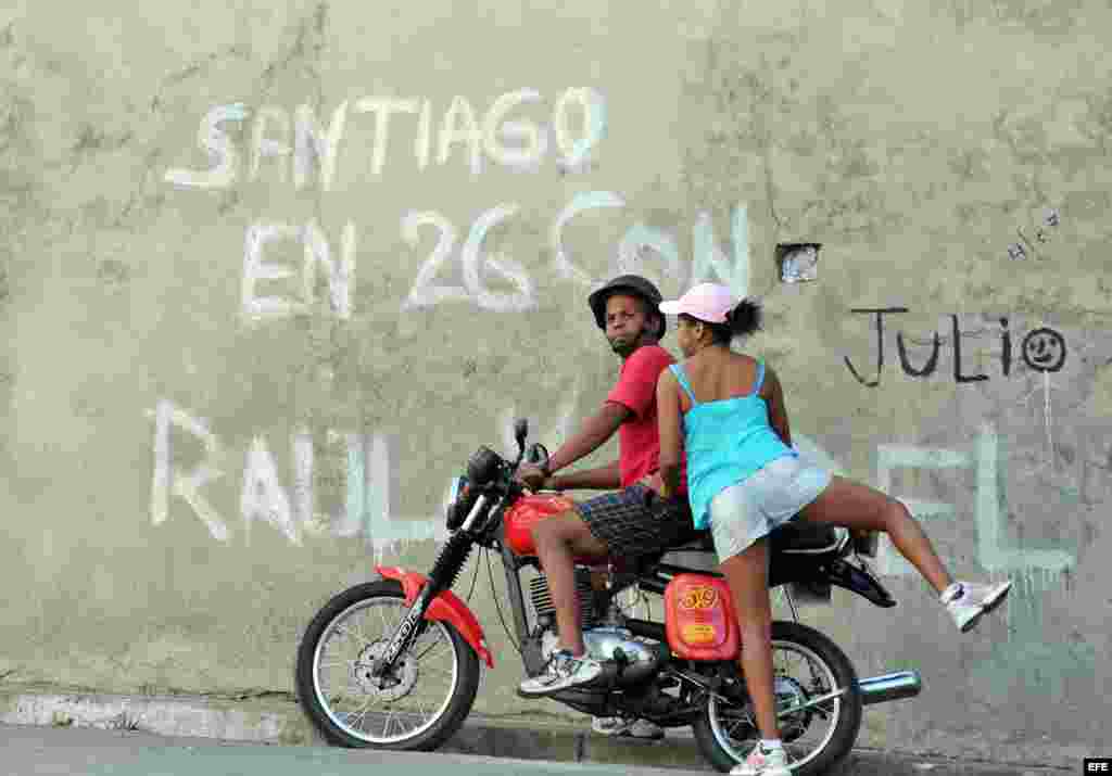 Una mujer se sube en una moto en la ciudad de Santiago de Cuba.