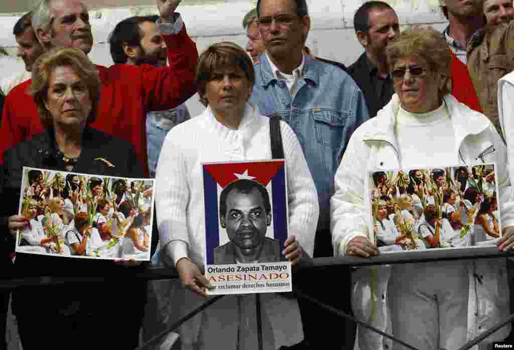 Activistas muestran carteles de las Damas de Blanco y Orlando Zapata Tamayo, frente a la Embajada de Cuba en Madrid, España. REUTERS/Andrea Comas