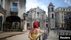 Una mujer espera junto a una cerca metálica, luego que se anunciara la muerte del cardenal Jaime Ortega, el viernes 26 de julio de 2019 en La Habana. REUTERS/Fernando Medina.