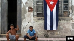 Dos niños posan frente a una casa en ruinas en Santiago de Cuba. EFE