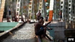 Jóvenes departen al lado de una vía férrea en Matanzas (Cuba).