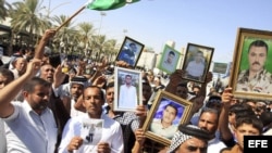 Unos ciudadanos iraquíes sostienen retratos parientes suyos presuntamente ejecutados por el yihadista Estado Islámico (EI) durante una manifestación contra el grupo terrorista en Kerbala, en el sur de Irak.