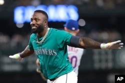 Randy Arozarena, de los Marineros de Seattle, celebra en primera base tras conseguir un hit durante la séptima entrada del partido de béisbol contra los Mets de Nueva York, el sábado 10 de agosto de 2024, en Seattle. (AP Photo/Jason Redmond)