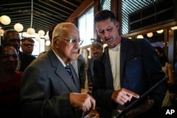 Ricardo Cabrisas conversa con un empresario ruso durante el foro empresarial celebrado en La Habana. (AP Photo/Ramon Espinosa)